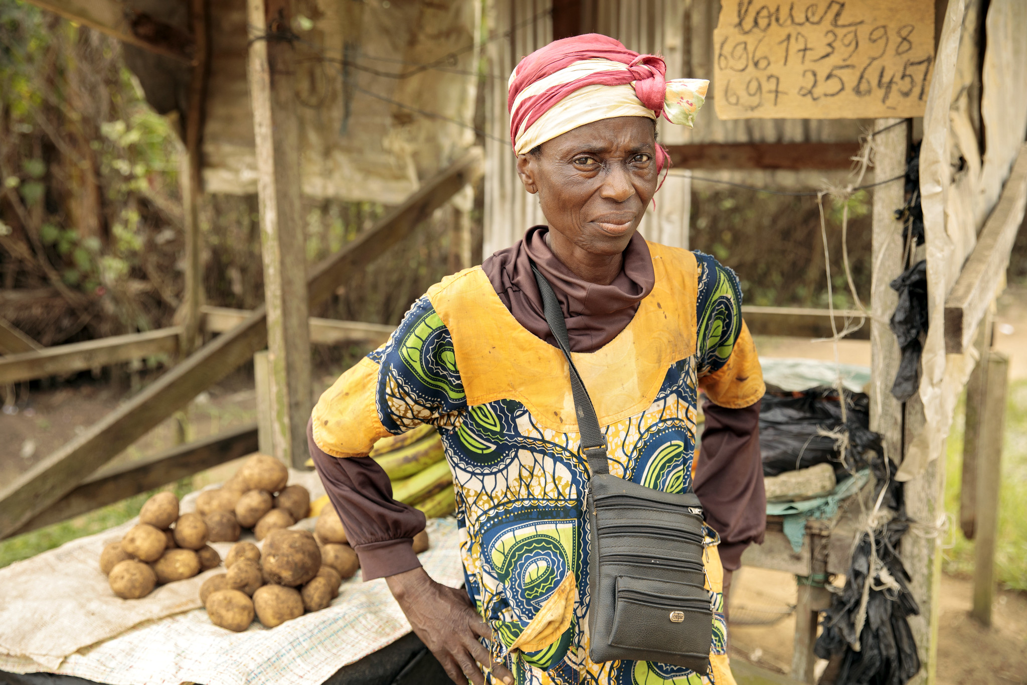 Woman standing in front of her small produce stand in Cameroon