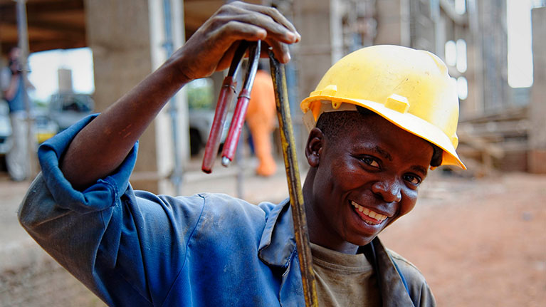 Man with hard hat smiling on construction site