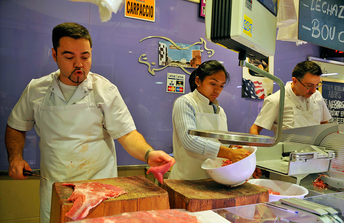 Three chefs preparing meat in butchers