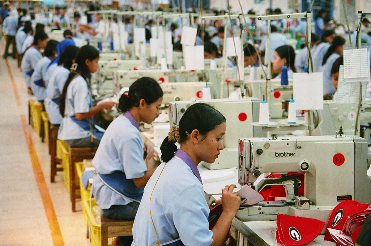 Rows of Asian sewing machinists working in factory