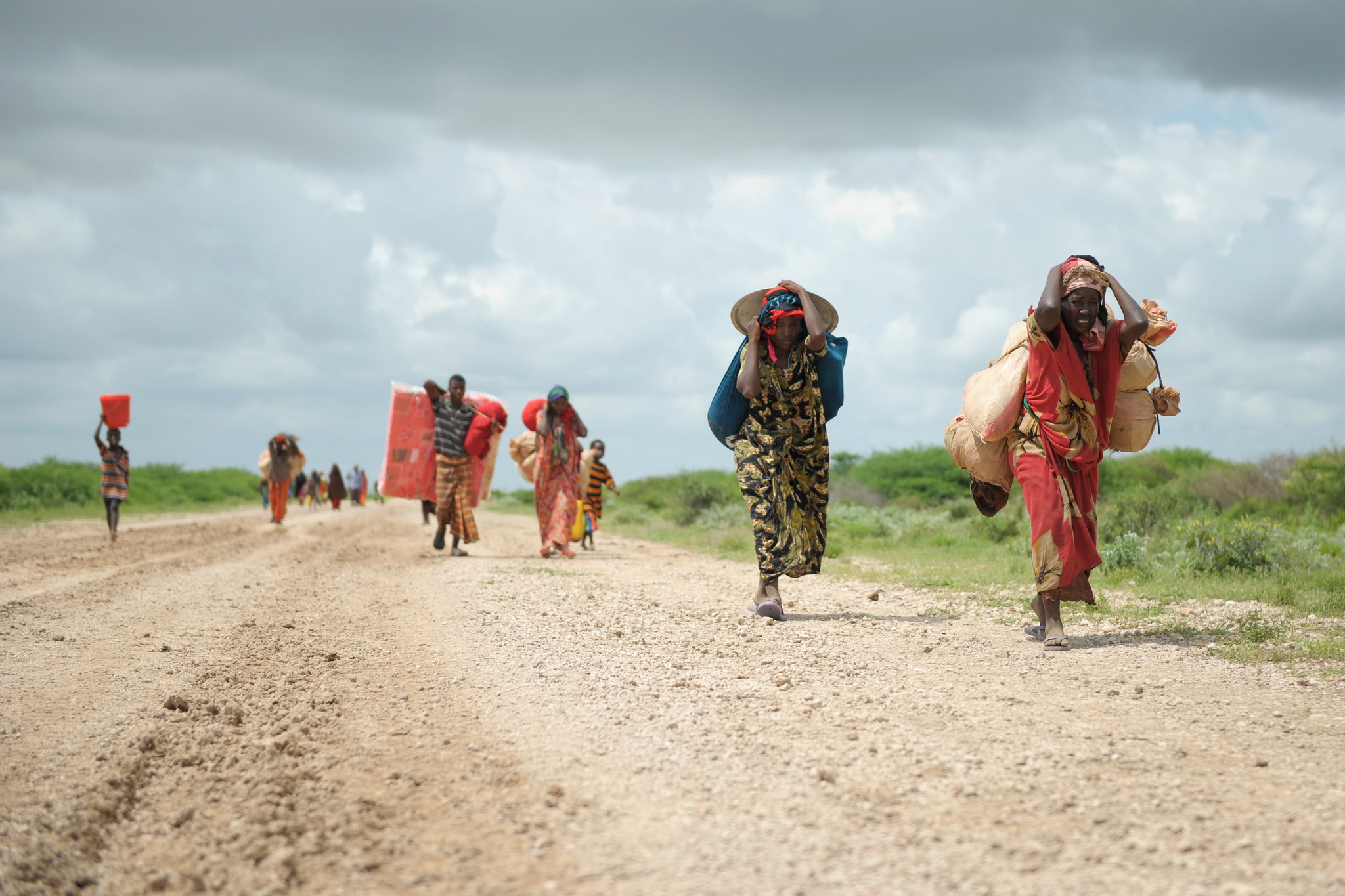Displaced men and women walking on a road in Somalia