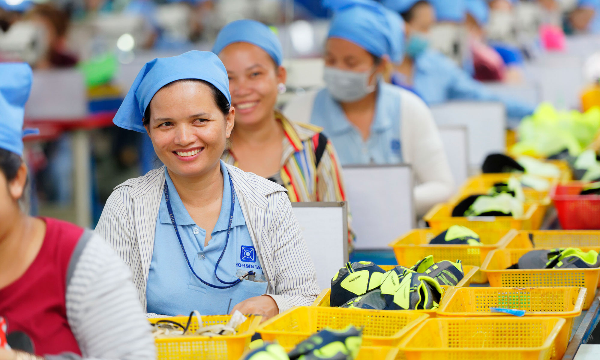 A factory worker is seen smiling during her shift in a footwear manufacturing plant in Cambodia. Photo : Marcel Crozet / ILO
