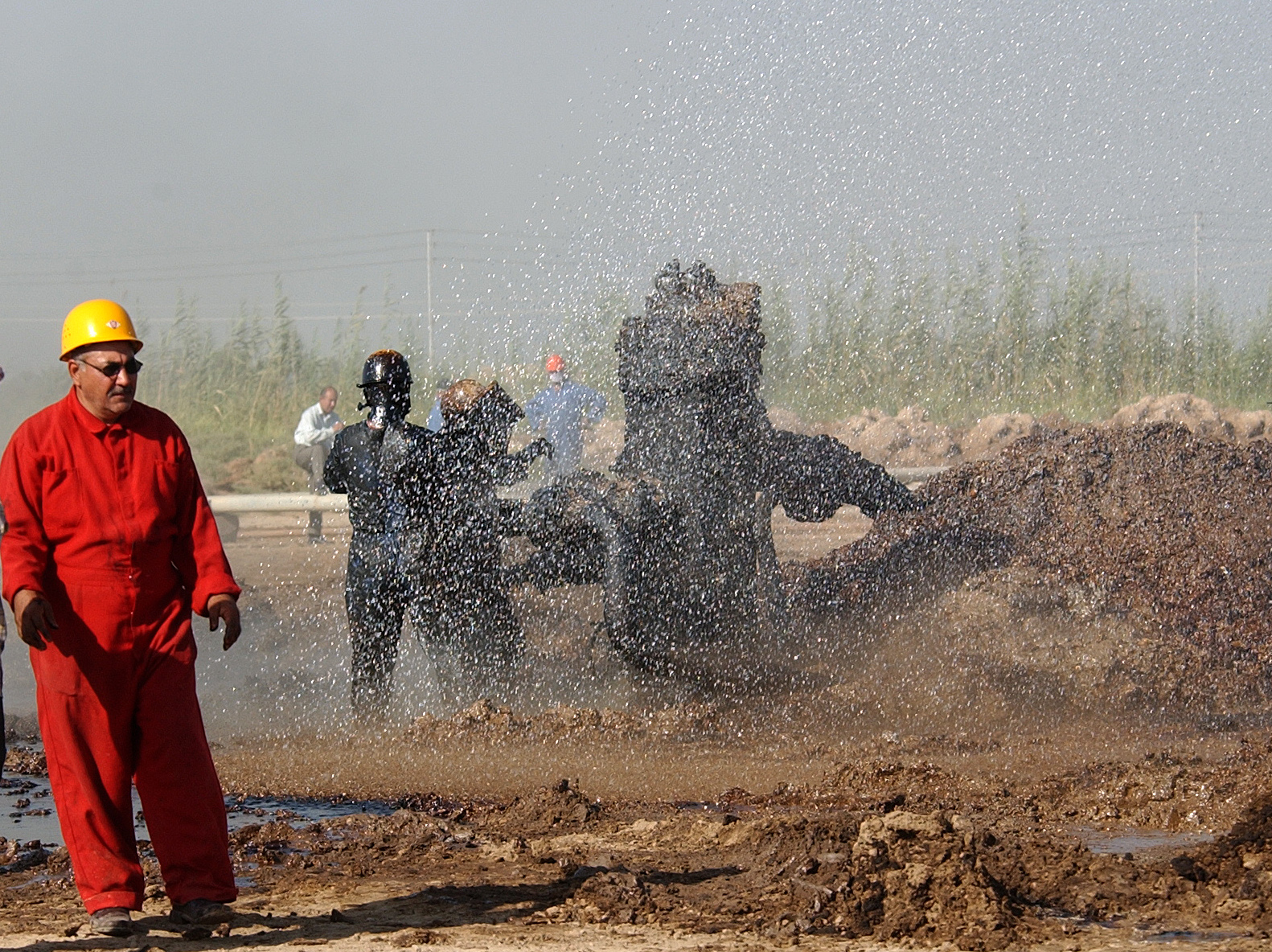 Oil engineers spray water to cool off oil wells in northern Iraq