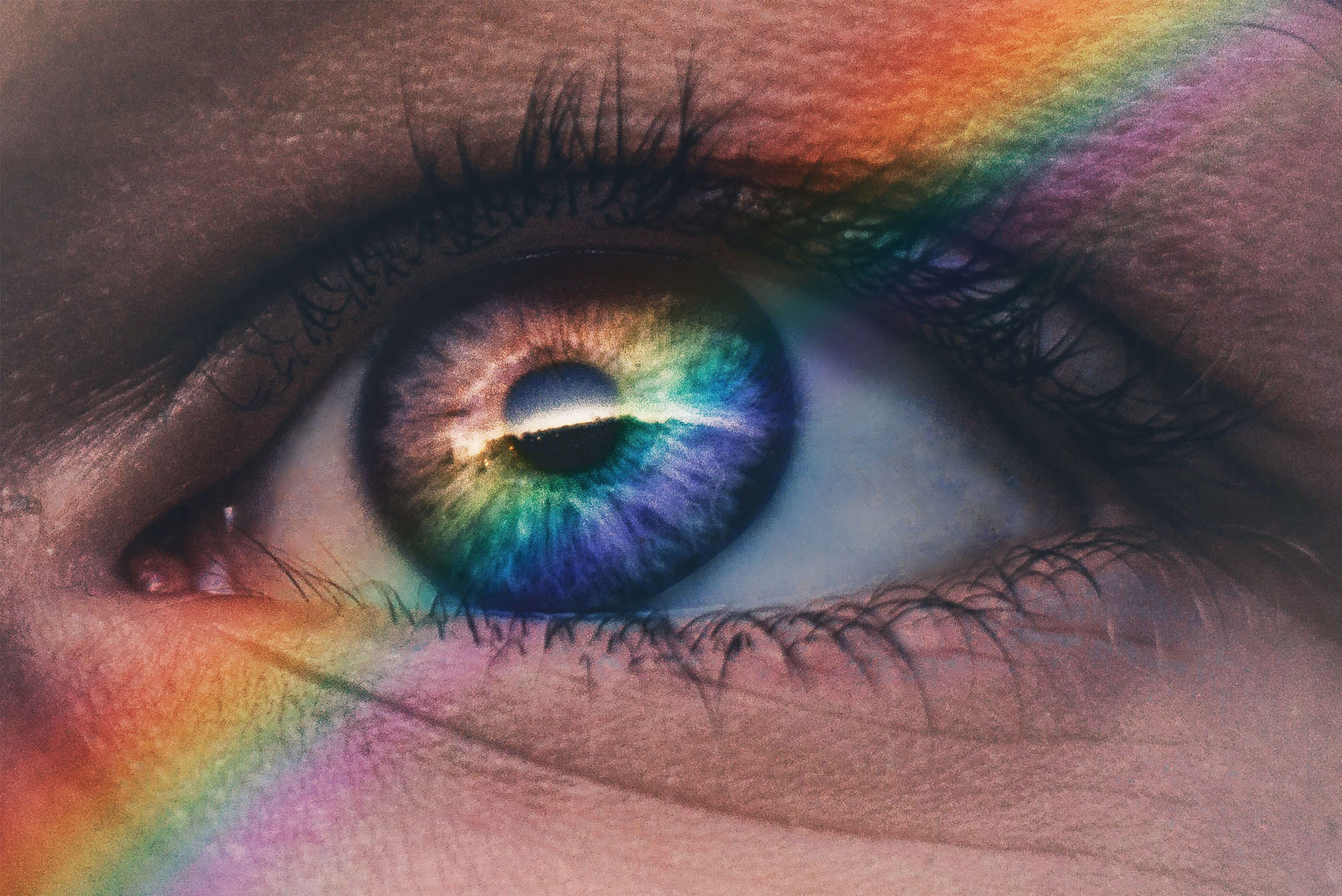 Close up image of an eye with rainbow across it