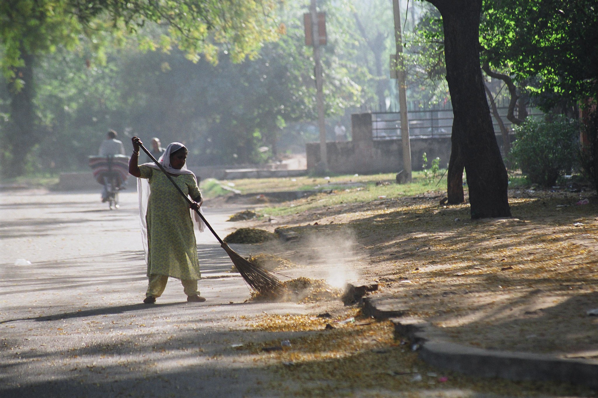 6 o'clock in the morning, domestic worker sweeping the street in front of a private property in the Golf Links area, Delhi.