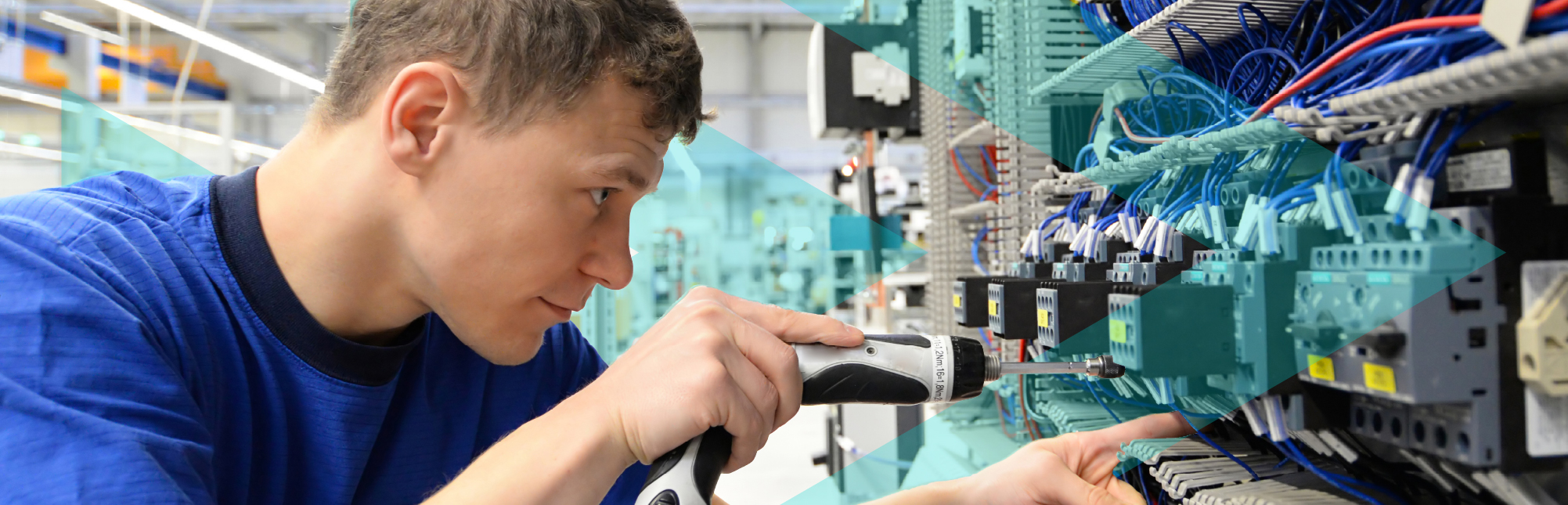 Young male operator assembles the machine in a modern high-tech factory - production of switch boxes for the industrial plant