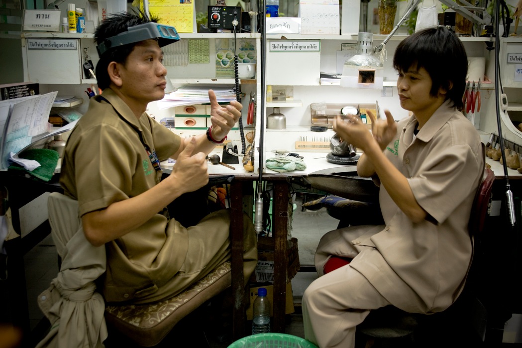 Two workers communicate in sign language in an office