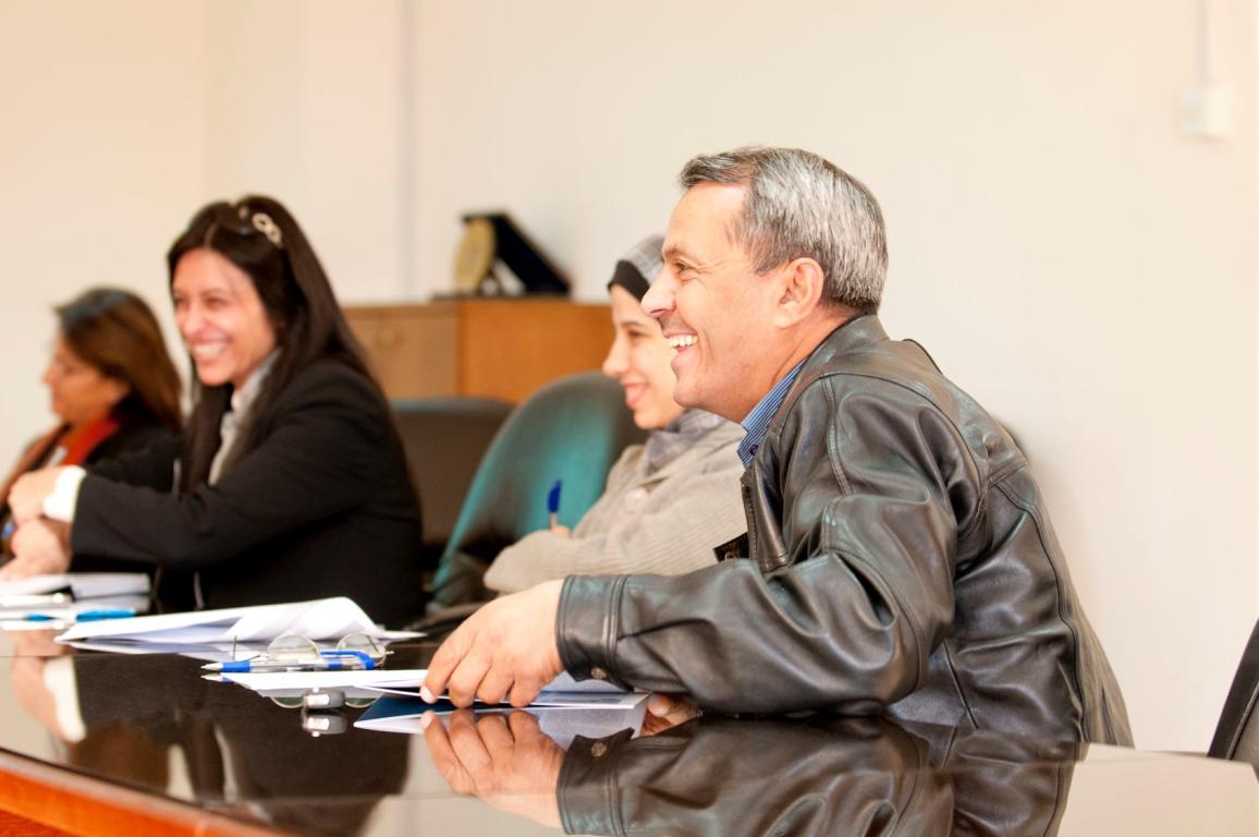 Group of people smiling around desk