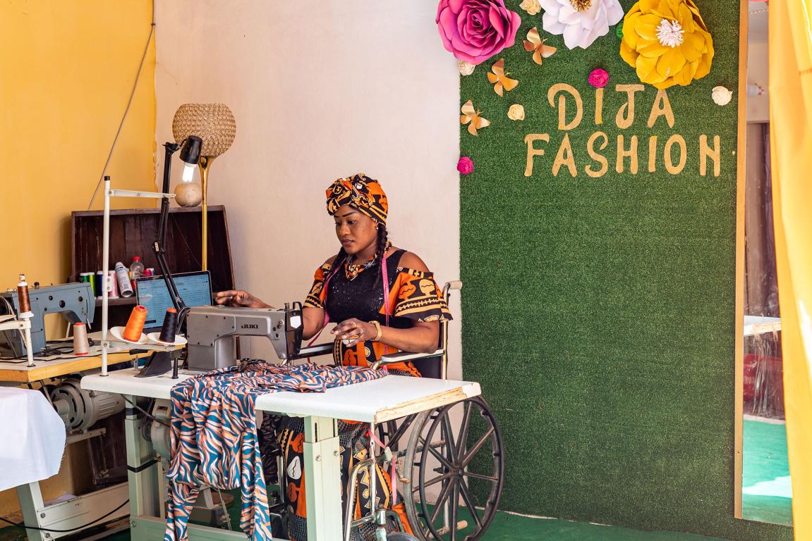 Lady in wheelchair making a dress using an electric sewing machine