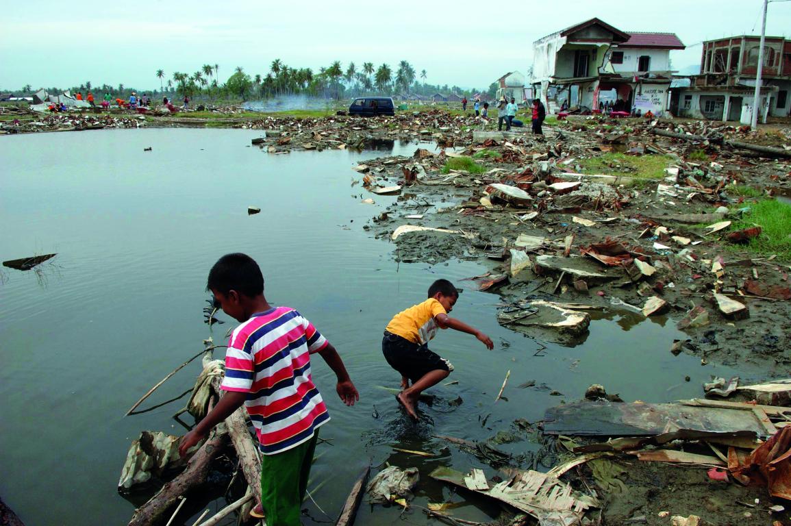 Children walking in a river after tsunami