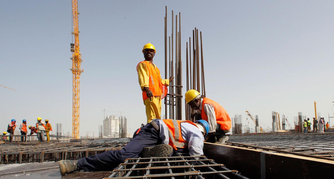 Men in yellow jumpsuits working on building construction site