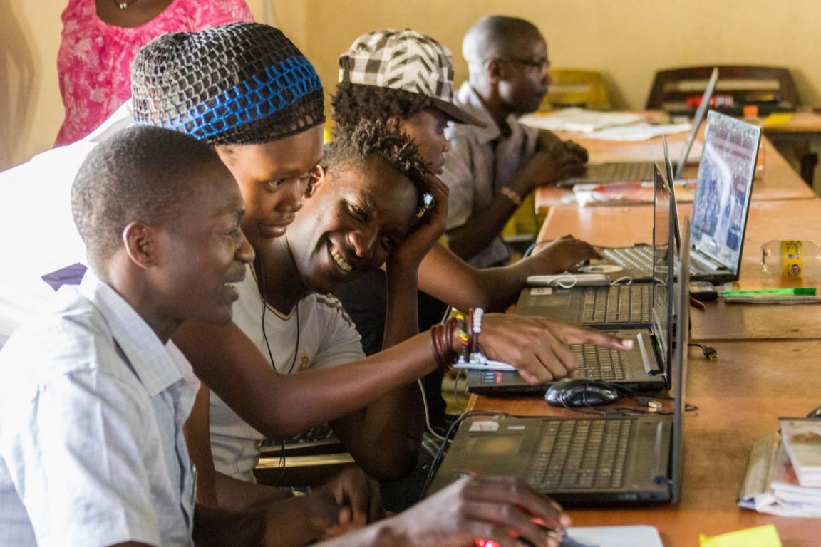 A woman gives a computer course to young African adults