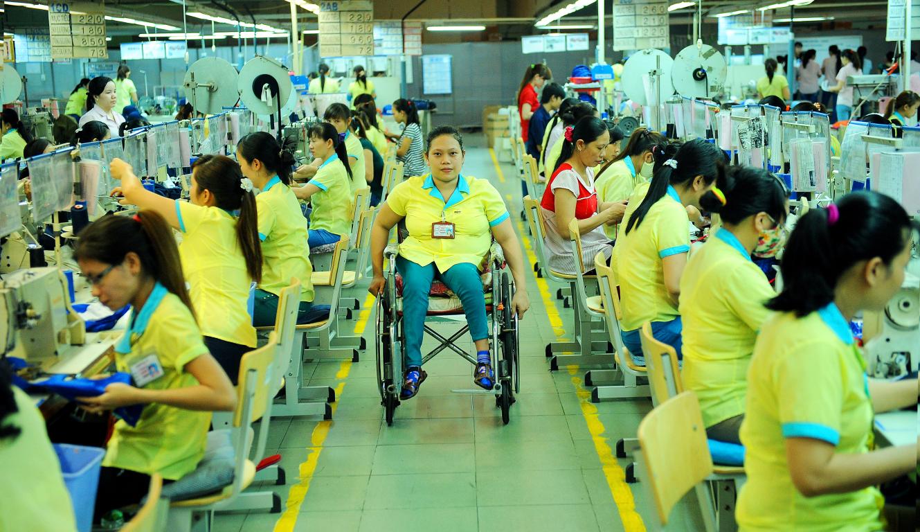 Disabled woman in a wheelchair working in a garment factory