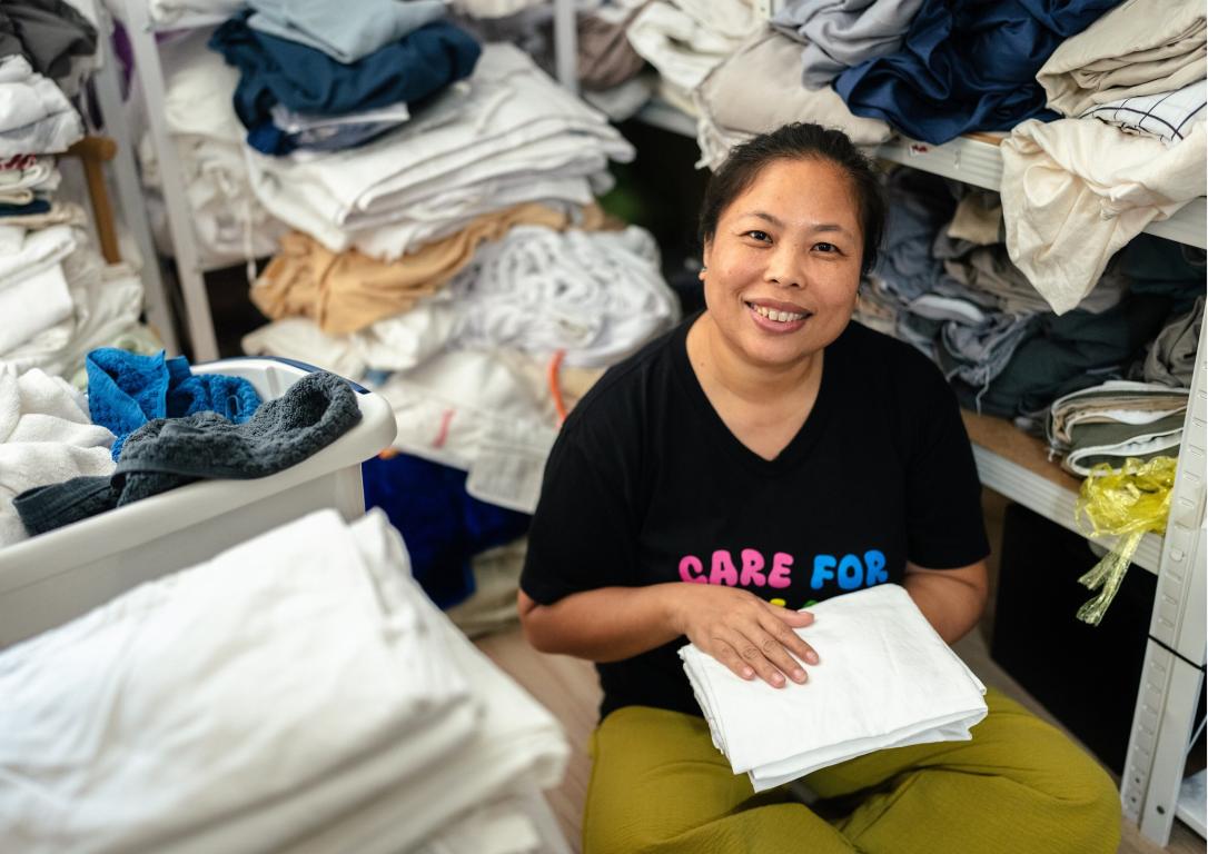 Woman in a room with piles of laundry
