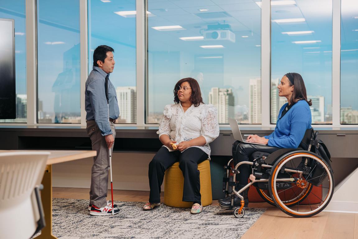 Three adults in a high level office block with various disabilities