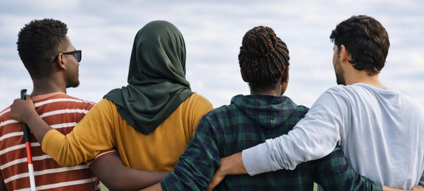 Two women and two men are standing close together, seen from behind