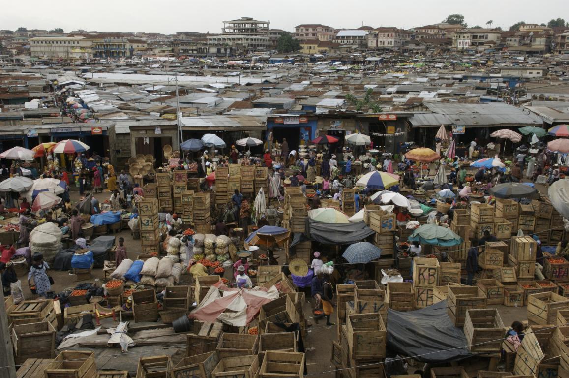 view of market in Asia showing rooftops, people, colourful parasols and wooden boxes