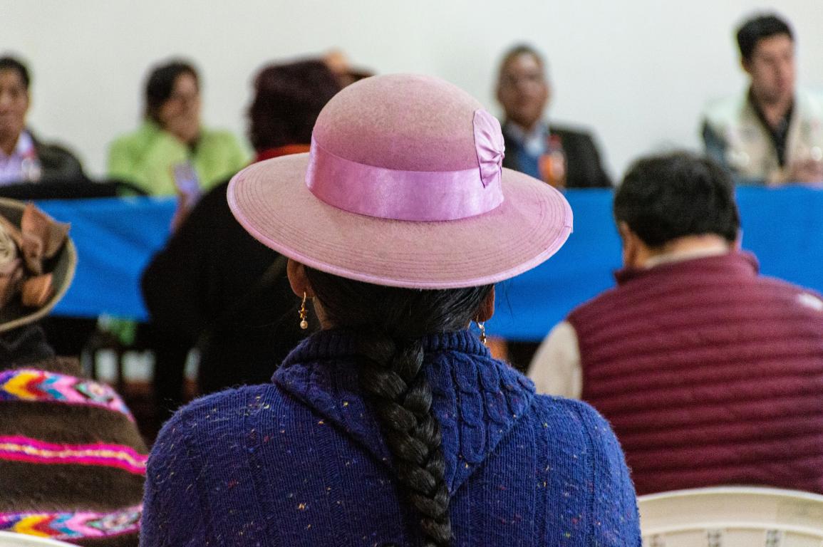 a woman wearing a pink hat in front of a group of people