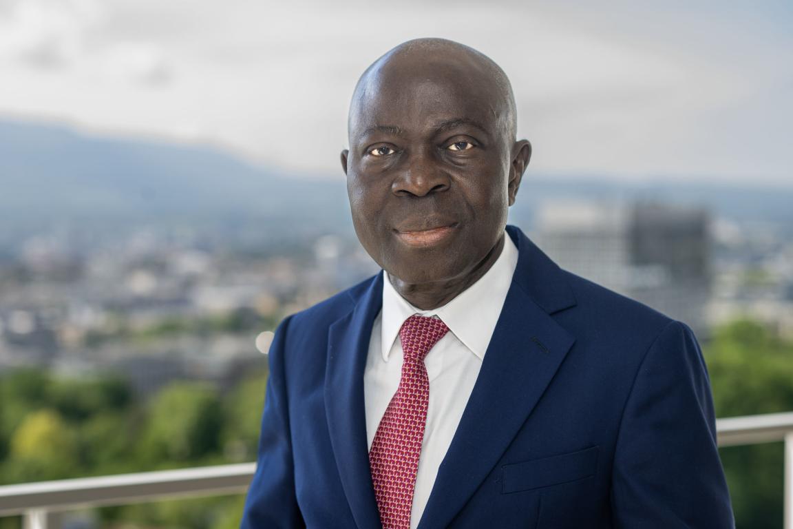 Gilbert F. Houngbo against a blurred hilly backdrop