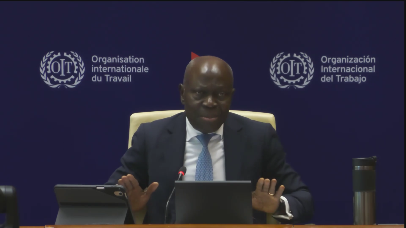 Gilbert Houngbo speaks in front of a blue ILO backdrop