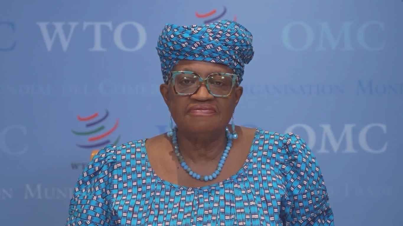 Ngozi Okonjo-Iweala stands before a branded banner