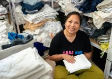 Woman in a room with piles of laundry