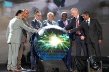 A group of men around a sphere lit 