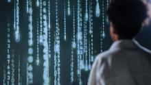 An individual viewing glowing numbers on a screen, symbolizing technology and data.